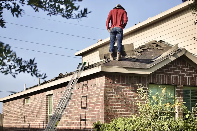 Professional roofer working on a residential roof in Fallentimber